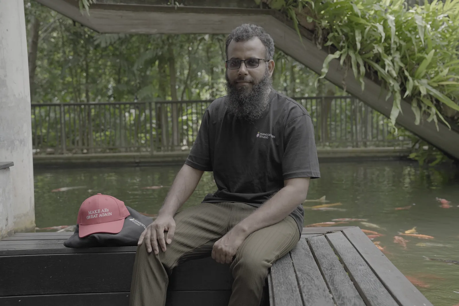 Seated on a wooden deck beside the koi pond at the Bhawal resort