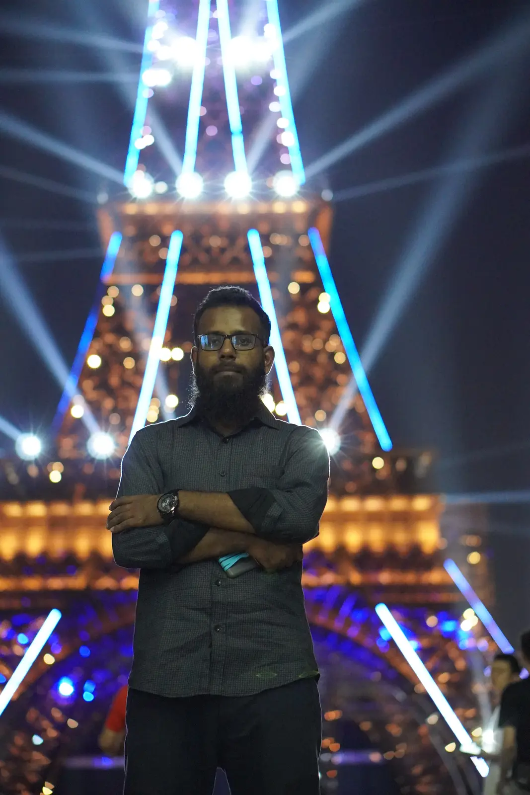 In front of the floodlit replica Eiffel Tower at night