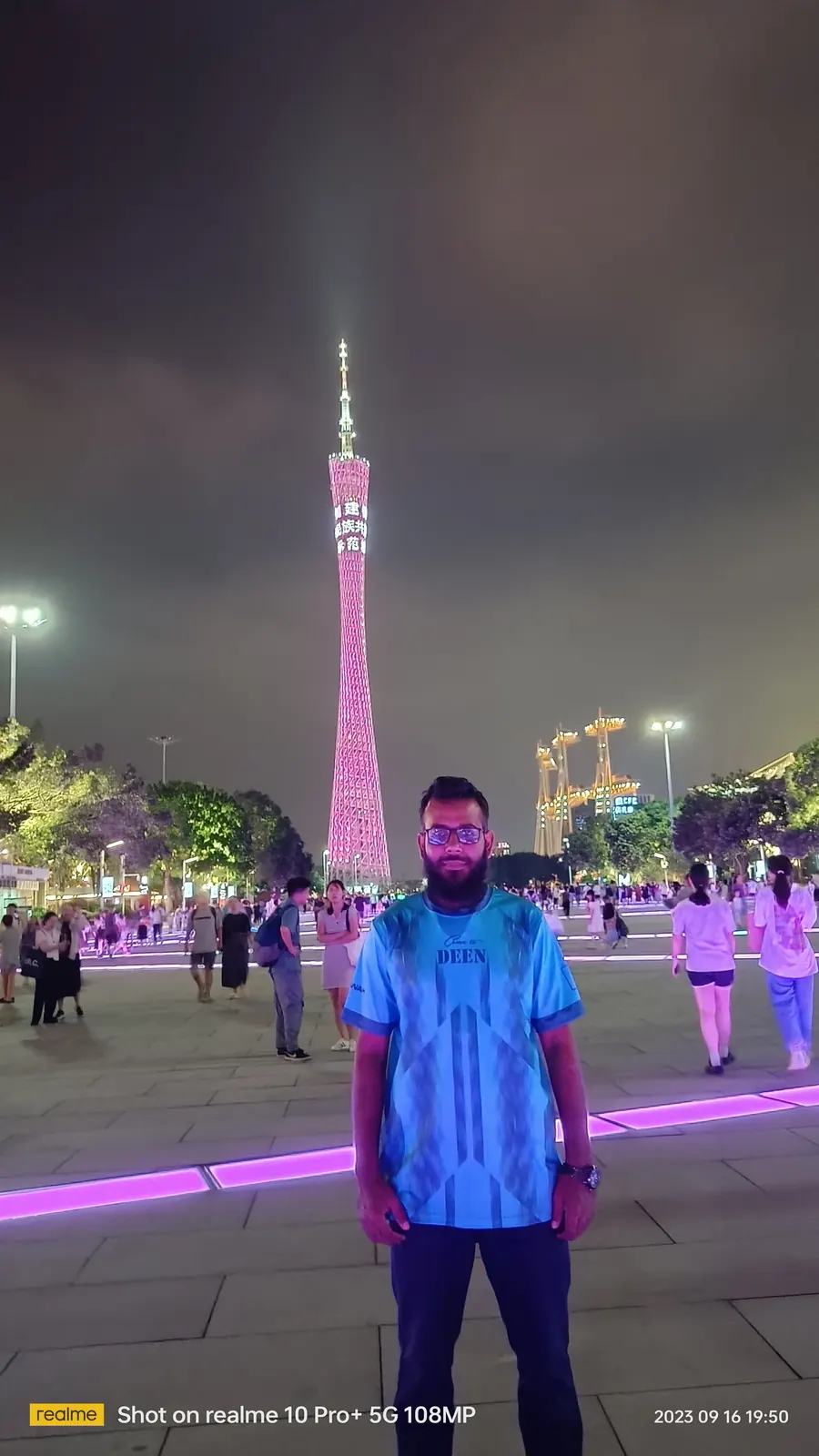 Standing on the riverside plaza with the Canton Tower lit pink behind