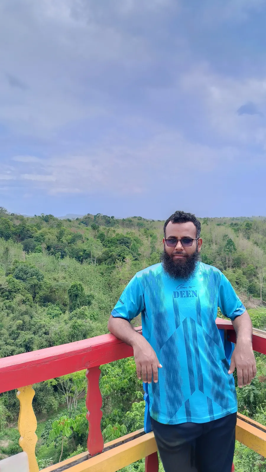 At a rainbow-painted railing above the forested lakeshore