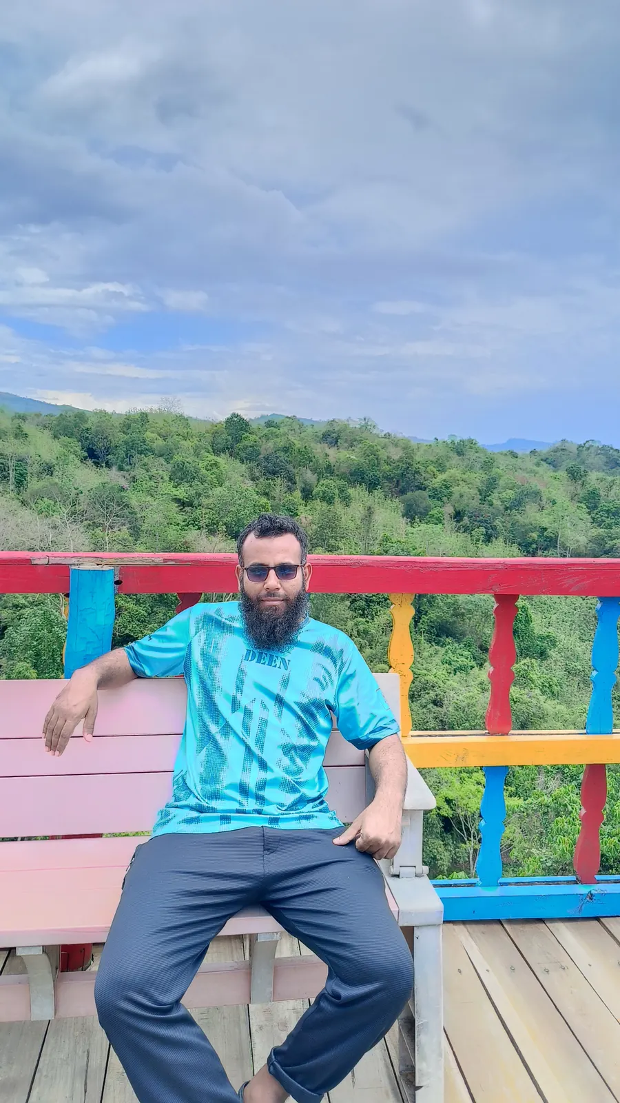 On a painted bench at the hillside viewpoint deck