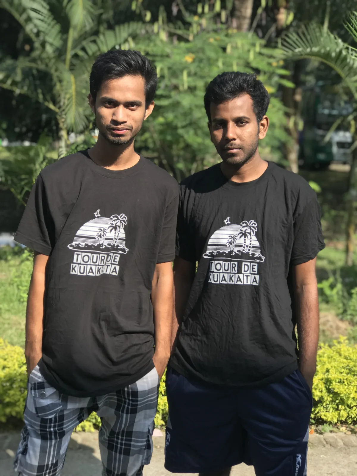 Two of us in matching tour t-shirts against sunlit greenery