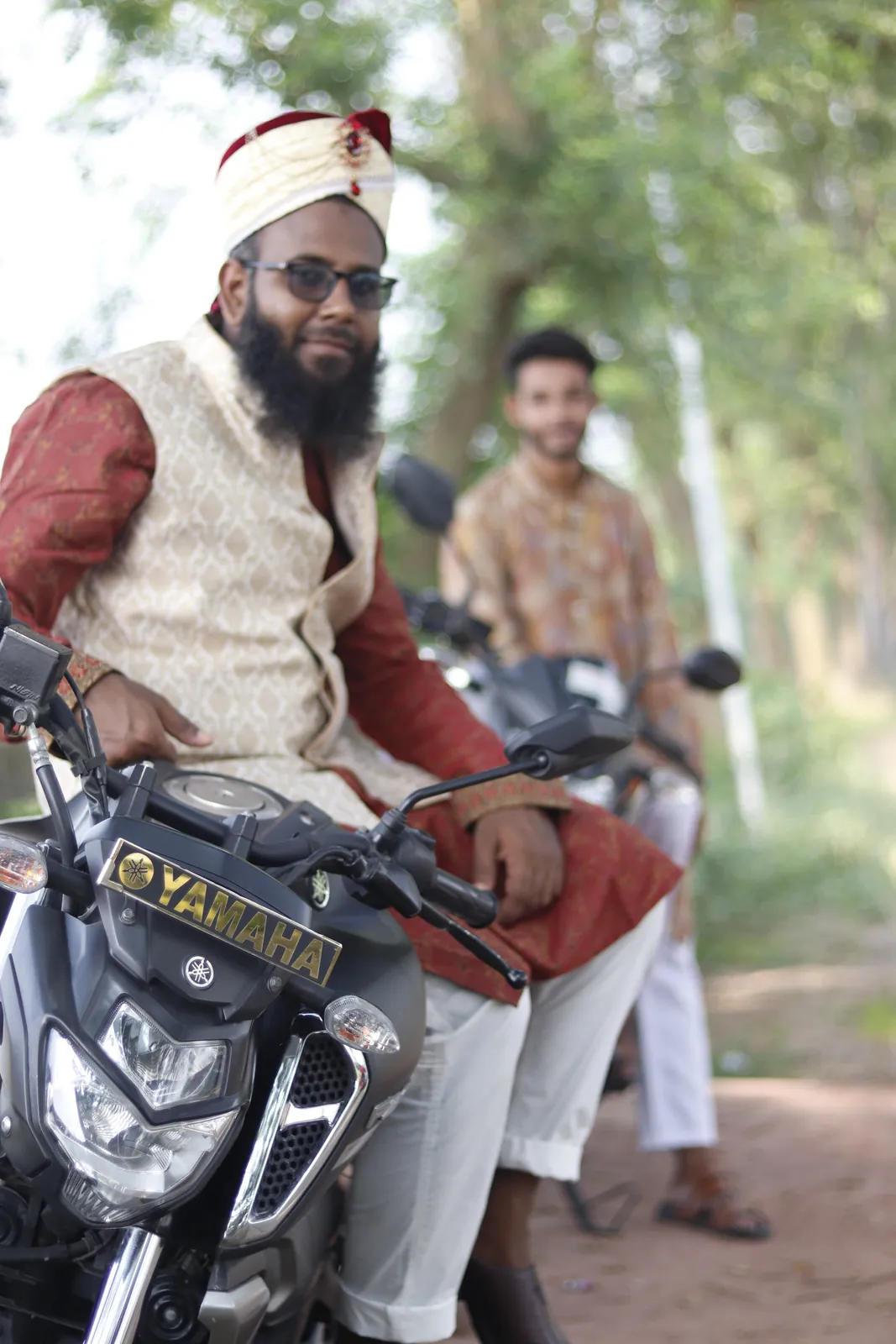 In full wedding attire, seated on a motorcycle