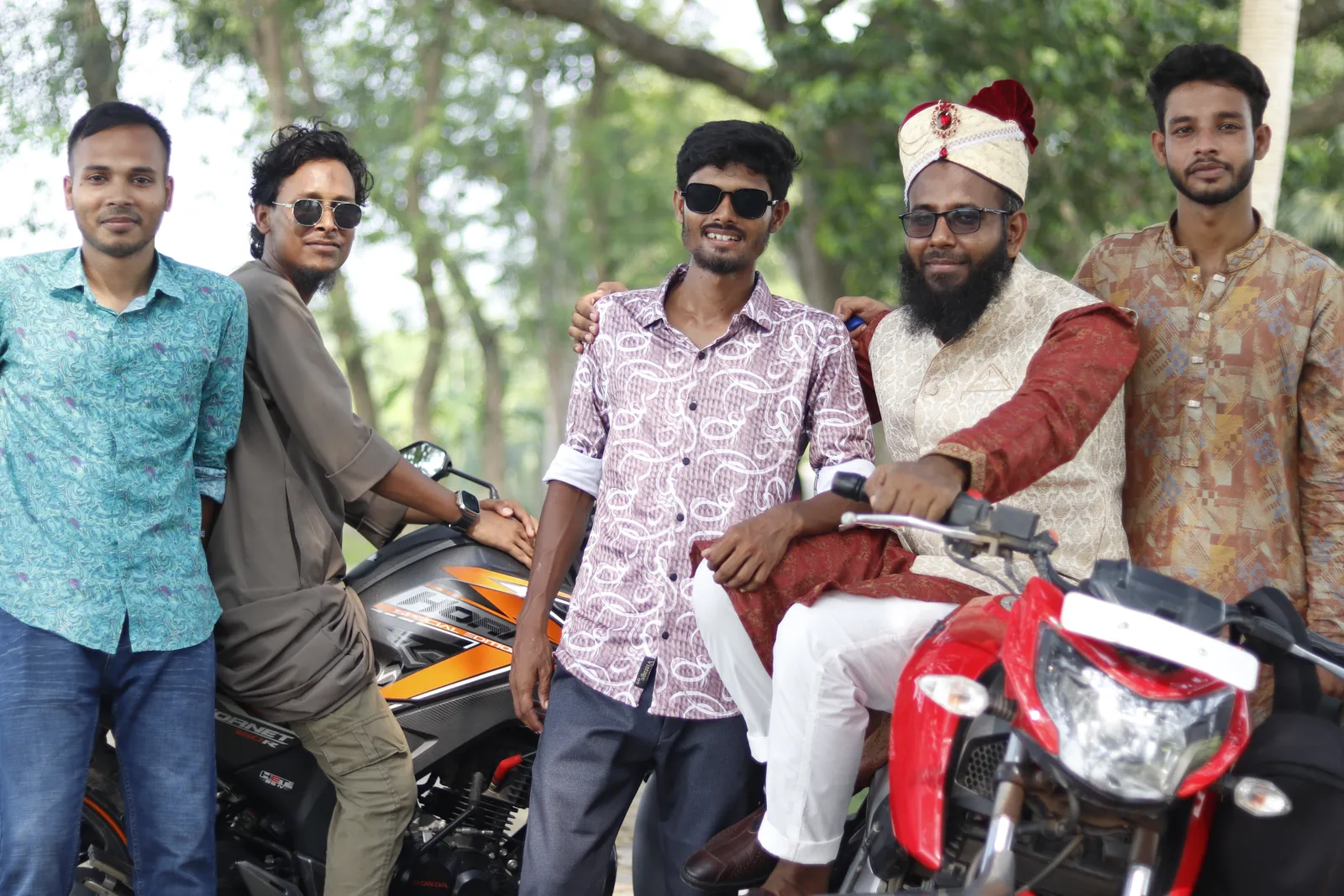 Surrounded by friends around a motorcycle on a wooded road