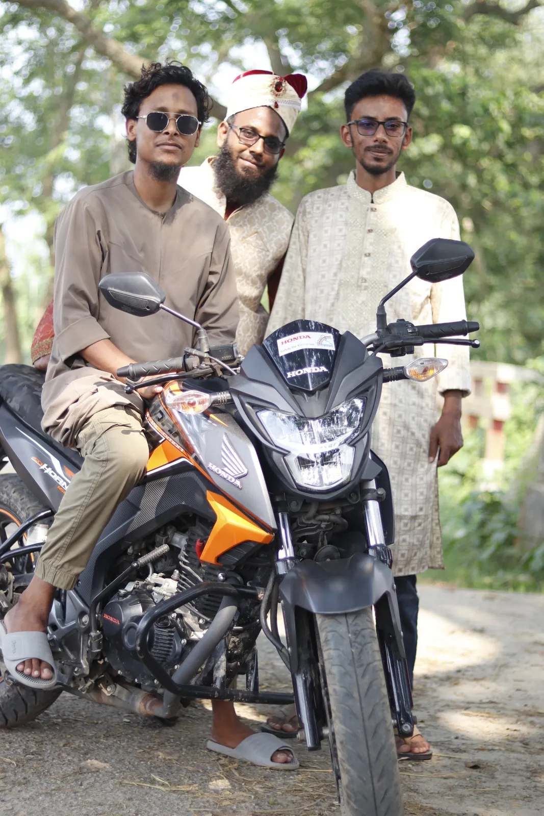 Posing with two friends around a motorcycle