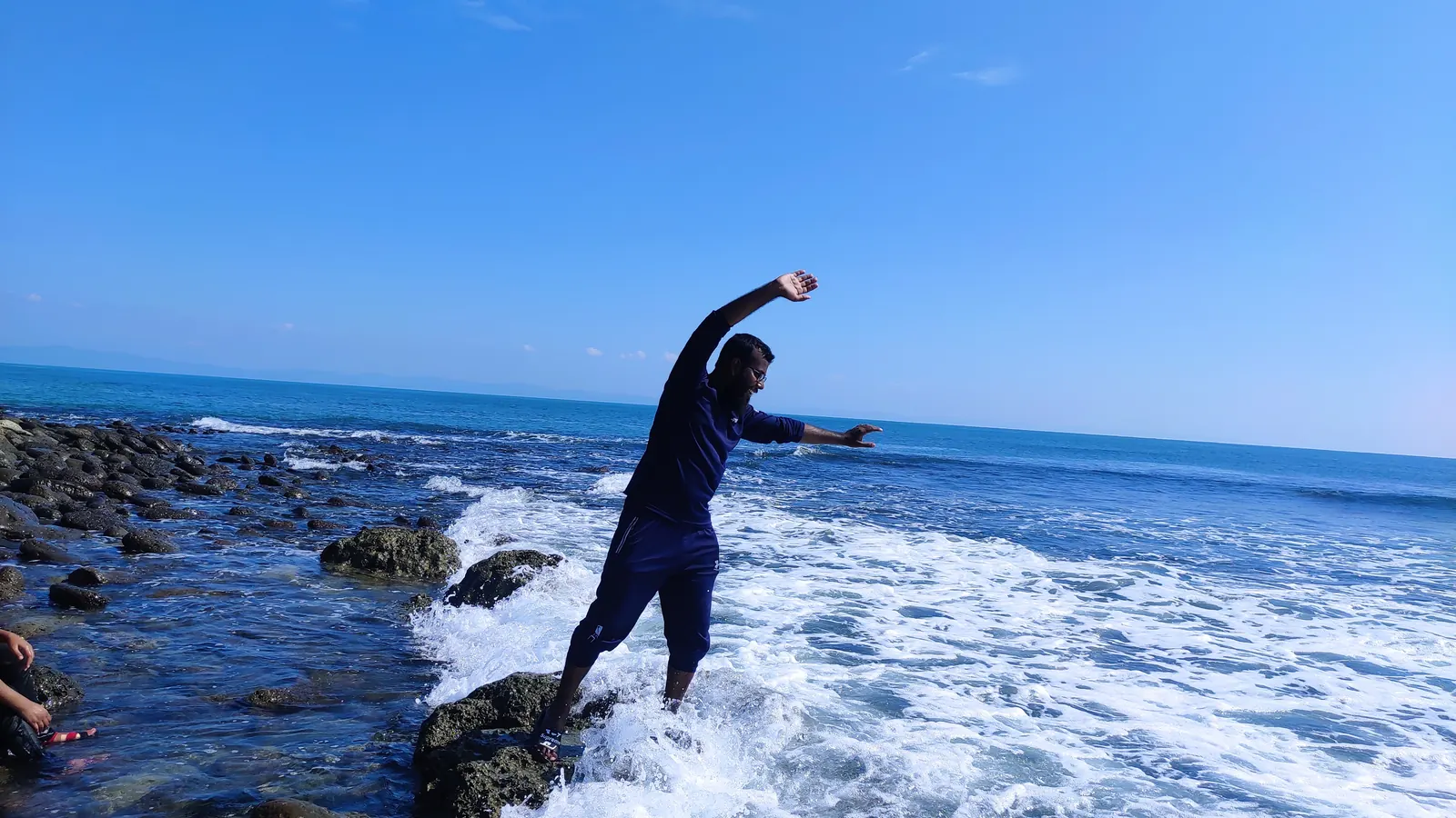 Braced on the rocks as a wave breaks over the reef