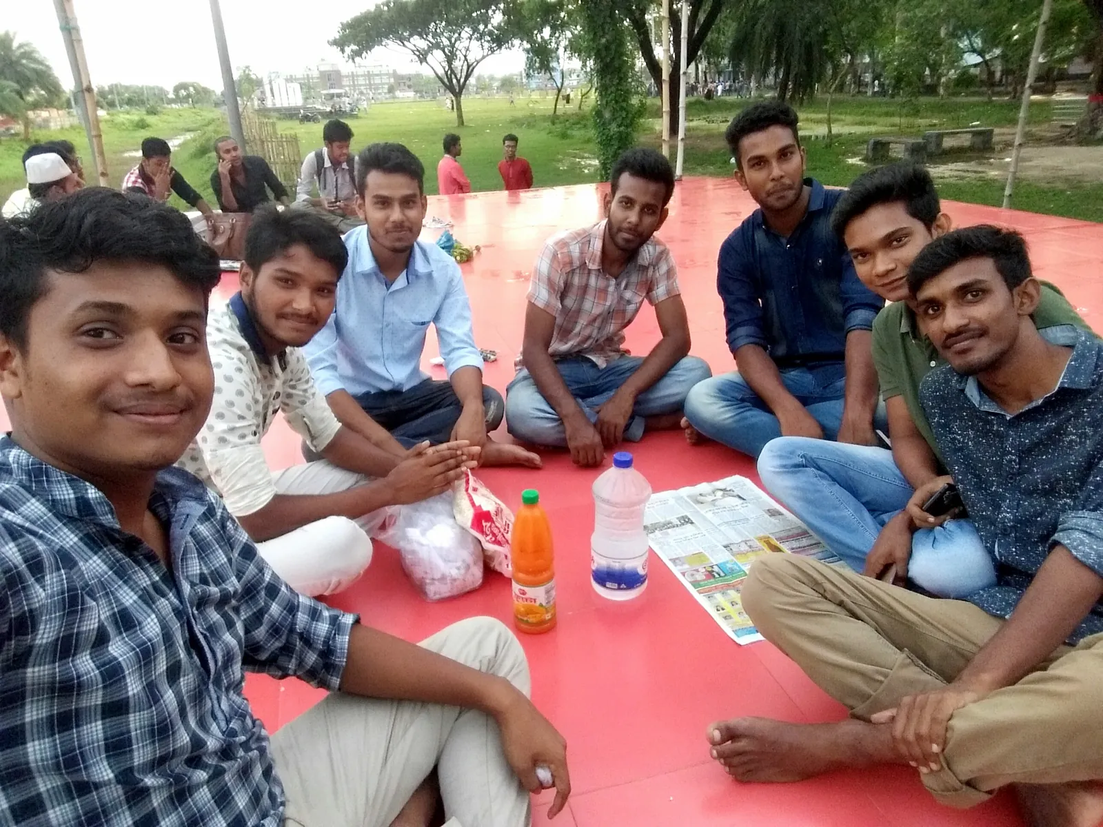 Picnic circle with friends on a red open-air platform in the park