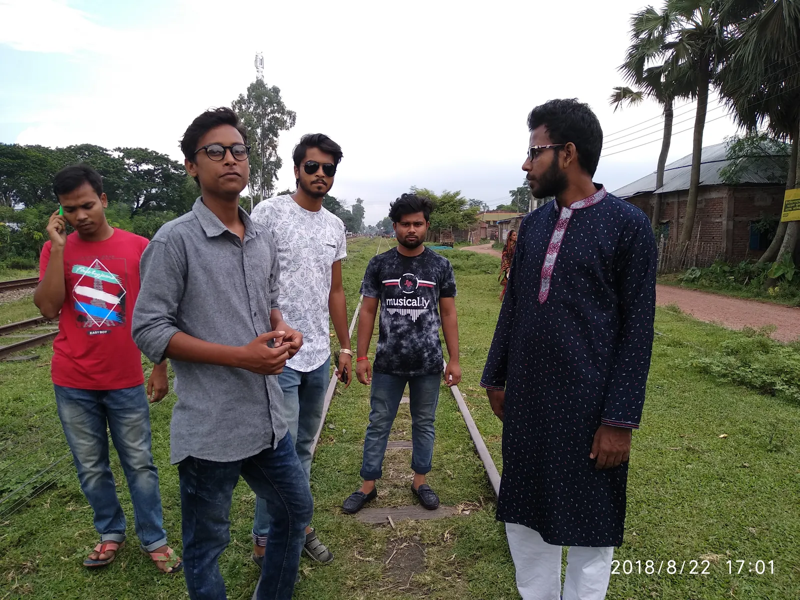 On the railway tracks with friends, palm trees on either side