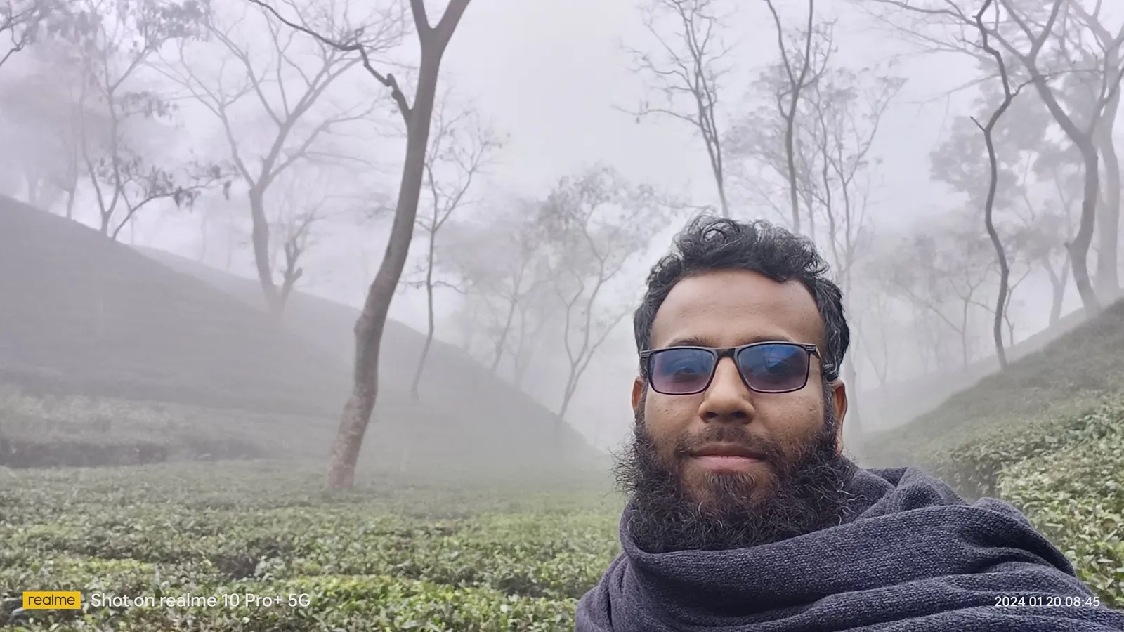 Portrait wrapped in a shawl among the tea bushes in heavy fog