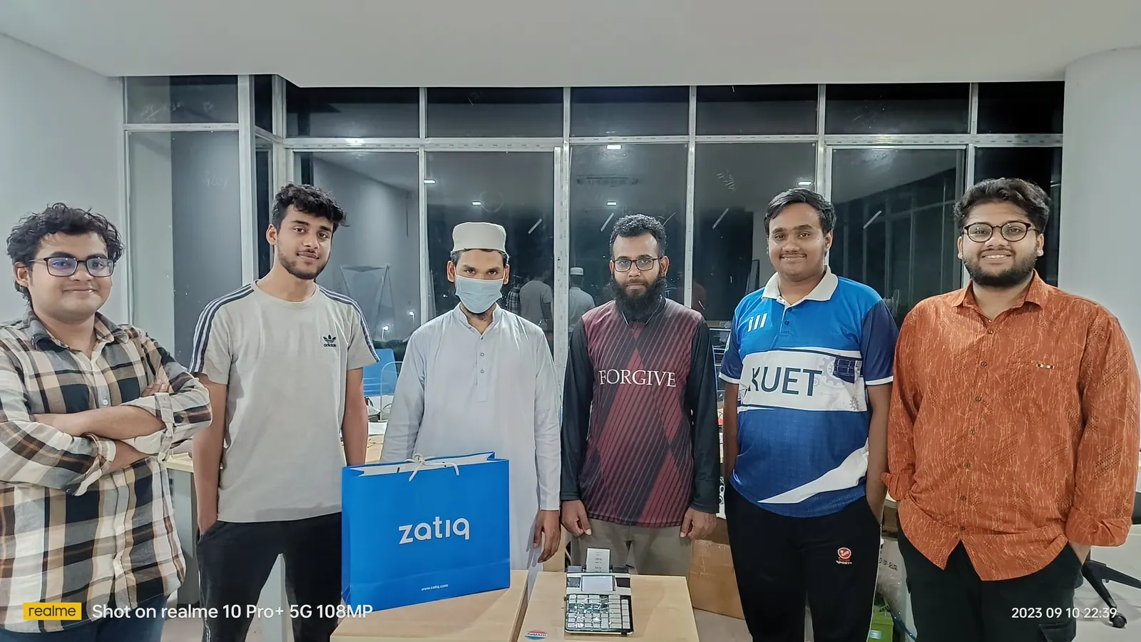 Six of the team lined up with a blue Zatiq bag after a late shift